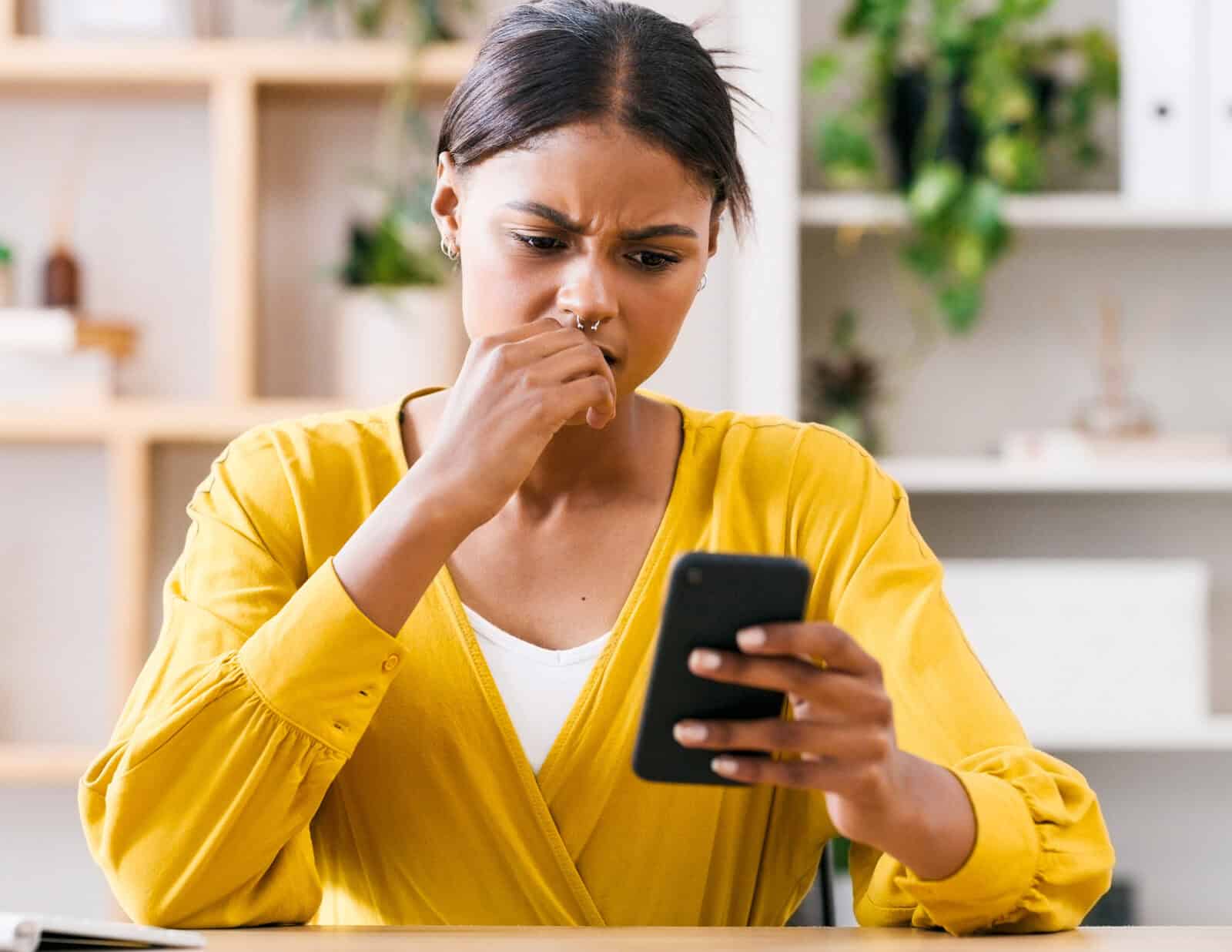 Woman feeling anxious while overthinking a message on her phone