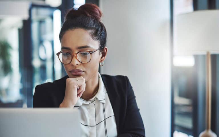 Woman overthinking while working on laptop, representing high-functioning anxiety