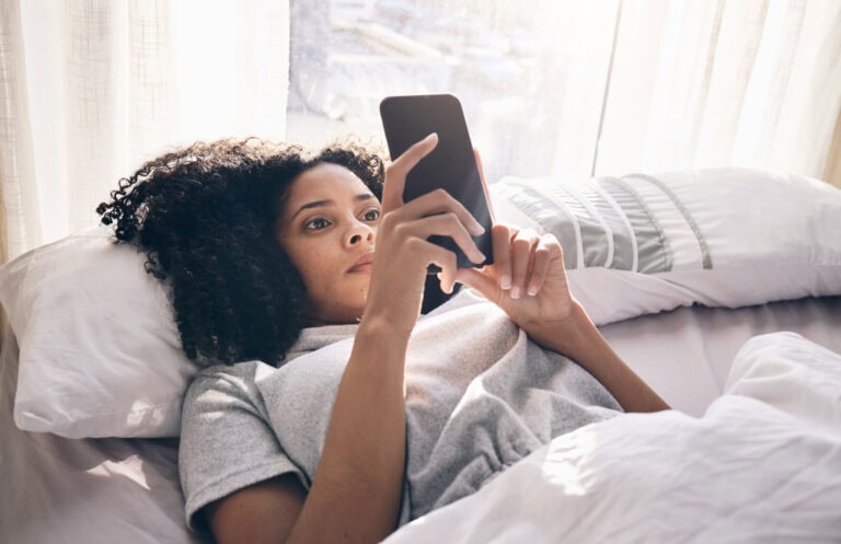 Woman Lying awake in bed with racing thoughts at night.